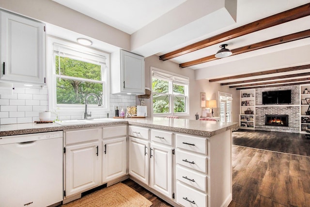 3025 Juneberry Ave SE, Grand Rapids, MI 49508 - kitchen featuring dishwasher, a sink, a brick fireplace, a peninsula, and dark wood-style floors