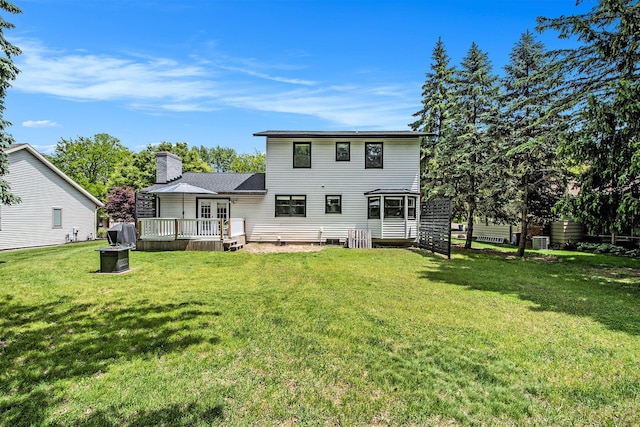 3025 Juneberry Ave SE, Grand Rapids, MI 49508 - rear view of house featuring a wooden deck, a chimney, and a lawn