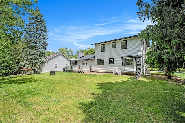 3025 Juneberry Ave SE, Grand Rapids, MI 49508 - rear view of property featuring a wooden deck, a lawn, a chimney, and cooling unit