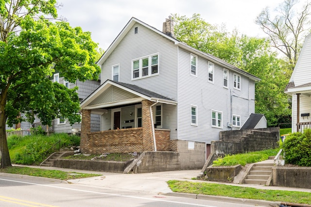733 Lafayette Ave NE, Grand Rapids, MI 49503 - american foursquare style home featuring stairs, a chimney, and covered porch