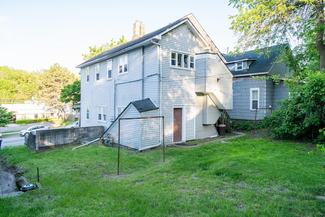 733 Lafayette Ave NE, Grand Rapids, MI 49503 - rear view of house with a chimney and a yard