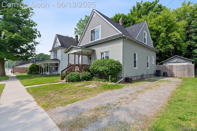 1 Jones St, Yale, MI 48097 - view of front of property featuring a chimney, a detached garage, a shingled roof, driveway, and board and batten siding