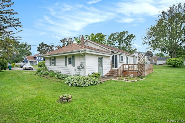 613 Genesee Ave, Gaines, MI 48436 - back of property featuring a wooden deck, a yard, and a chimney