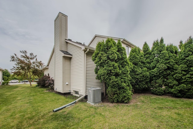 324 Redrock Ct, Ann Arbor, MI 48103 - view of side of home featuring central air condition unit, a chimney, and a lawn