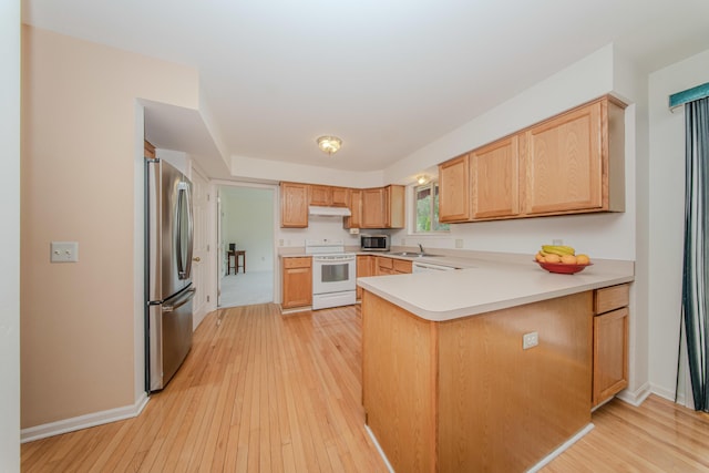 324 Redrock Ct, Ann Arbor, MI 48103 - kitchen with stainless steel appliances, a peninsula, light wood finished floors, under cabinet range hood, and light countertops