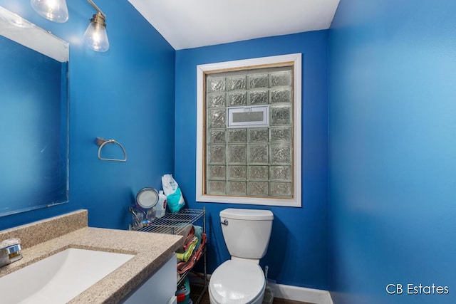 1044 Dahlia Ave, Wayland, MI 49348 - half bathroom featuring toilet, vanity, and baseboards