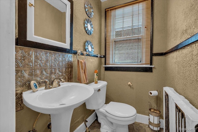 2505 Chicago Blvd, Detroit, MI 48206 - bathroom featuring a textured wall, toilet, baseboards, and a sink