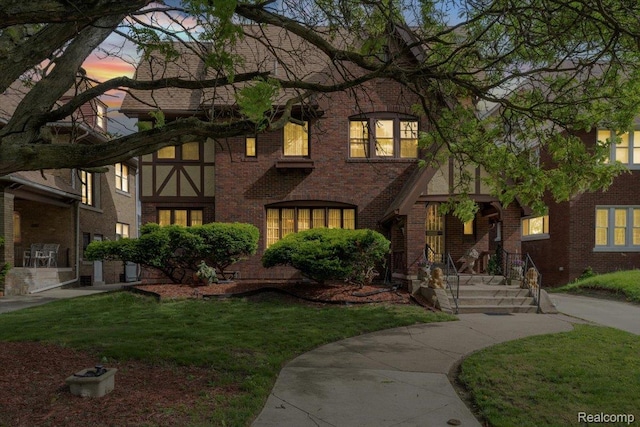 2505 Chicago Blvd, Detroit, MI 48206 - tudor-style house featuring a lawn, brick siding, and covered porch
