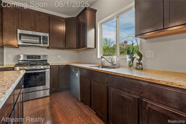 305 Beaver Run, Holly, MI 48442 - kitchen with appliances with stainless steel finishes, a sink, dark wood finished floors, dark brown cabinets, and light stone countertops