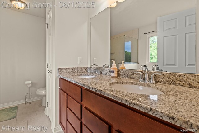305 Beaver Run, Holly, MI 48442 - bathroom with double vanity, toilet, tile patterned flooring, a shower with shower door, and baseboards