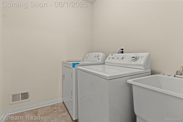 305 Beaver Run, Holly, MI 48442 - laundry room with separate washer and dryer, baseboards, and light stone finish flooring