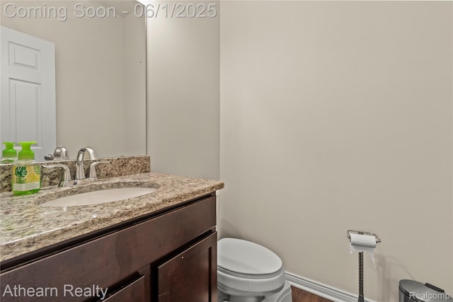 305 Beaver Run, Holly, MI 48442 - half bath featuring toilet, vanity, baseboards, and wood finished floors