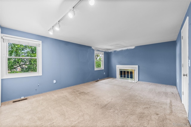 5138 Bayside Dr, Troy, MI 48098 - unfurnished living room featuring track lighting, a fireplace with flush hearth, and carpet flooring