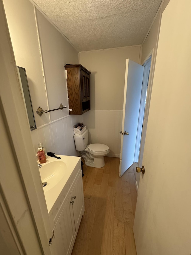 13497 Mark St, Southgate, MI 48195 - bathroom with a textured ceiling, wood finished floors, a wainscoted wall, vanity, and toilet