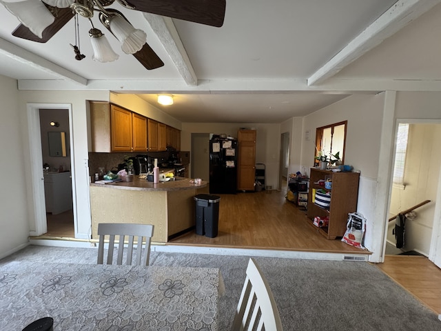 13497 Mark St, Southgate, MI 48195 - kitchen with black refrigerator with ice dispenser, light wood-type flooring, brown cabinets, beam ceiling, and a peninsula