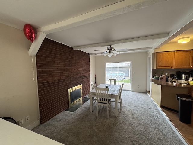 13497 Mark St, Southgate, MI 48195 - dining room featuring beamed ceiling, light carpet, a fireplace, ceiling fan, and baseboards