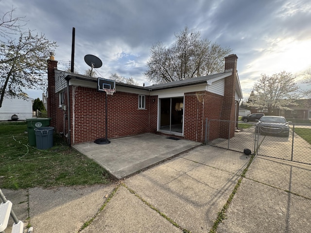 13497 Mark St, Southgate, MI 48195 - back of house featuring a chimney, brick siding, a gate, and a patio area