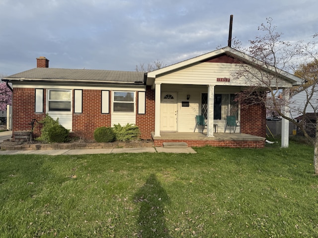 13497 Mark St, Southgate, MI 48195 - view of front of property with brick siding, a front yard, a porch, and a chimney
