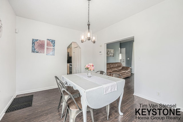 258 Ann St NE, Grand Rapids, MI 49505 - dining space featuring dark wood-type flooring, a chandelier, and arched walkways