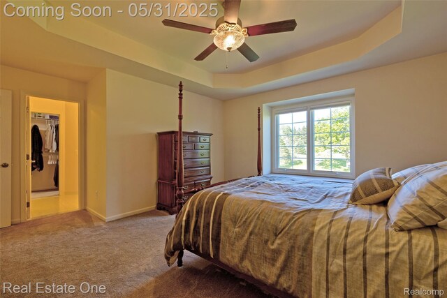 1572 S Hadley Rd, Ortonville, MI 48462 - carpeted bedroom with a raised ceiling, baseboards, a walk in closet, and a ceiling fan
