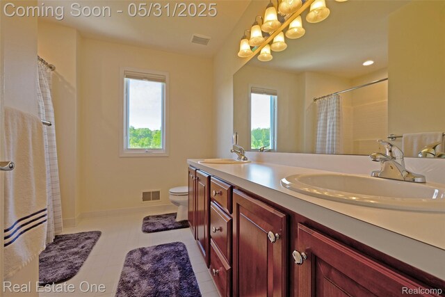 1572 S Hadley Rd, Ortonville, MI 48462 - bathroom with plenty of natural light, double vanity, toilet, and baseboards