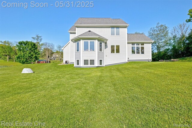 1572 S Hadley Rd, Ortonville, MI 48462 - back of house featuring a lawn and cooling unit