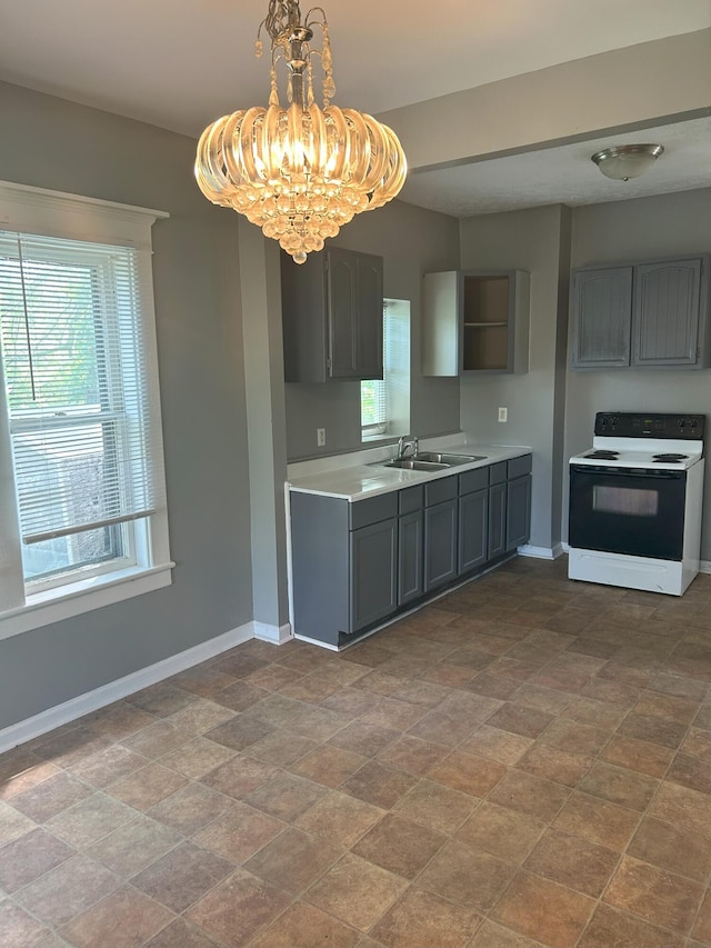 94 E Burnham St, Battle Creek, MI 49015 - kitchen with electric range oven, a chandelier, gray cabinets, and healthy amount of natural light