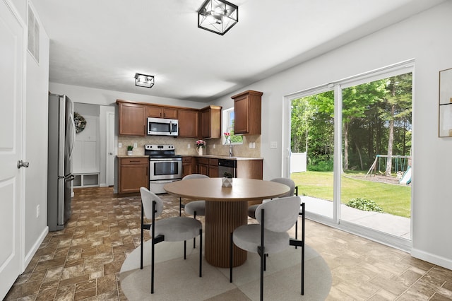 10126 Castle Creek Cir, Galesburg, MI 49053 - kitchen with stainless steel appliances, tasteful backsplash, baseboards, light countertops, and stone finish floors