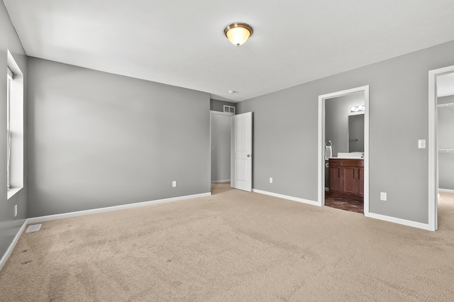 10126 Castle Creek Cir, Galesburg, MI 49053 - unfurnished bedroom featuring a walk in closet, carpet floors, baseboards, connected bathroom, and a closet