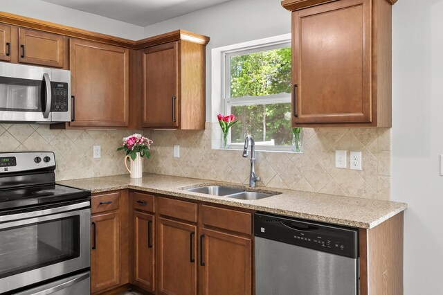 10126 Castle Creek Cir, Galesburg, MI 49053 - kitchen with appliances with stainless steel finishes, a sink, backsplash, and brown cabinets