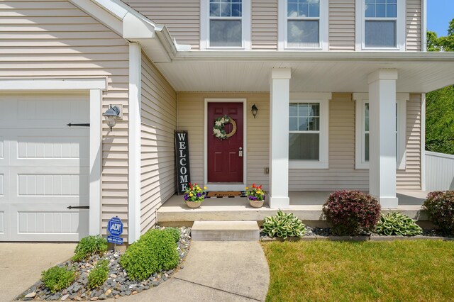 10126 Castle Creek Cir, Galesburg, MI 49053 - doorway to property featuring covered porch and a garage
