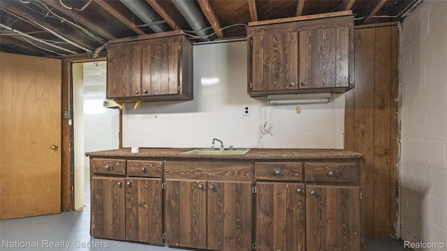 3446 17th St, Wyandotte, MI 48192 - kitchen with a sink, dark brown cabinets, dark countertops, and concrete flooring