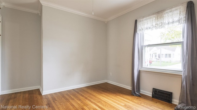 3446 17th St, Wyandotte, MI 48192 - spare room featuring crown molding, light wood-type flooring, and baseboards