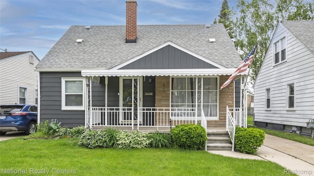 3446 17th St, Wyandotte, MI 48192 - view of front of house featuring covered porch, a shingled roof, a chimney, and board and batten siding