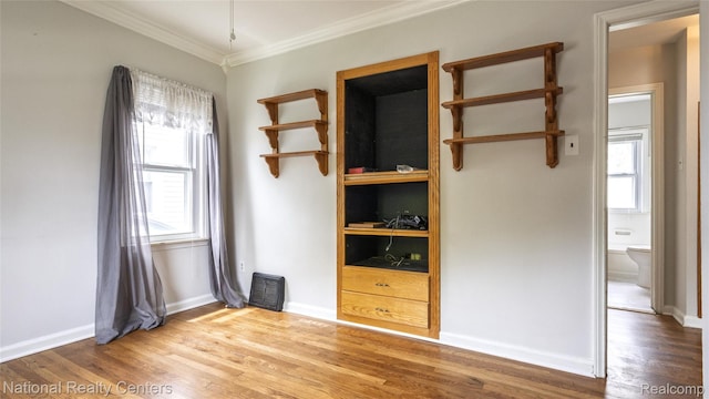 3446 17th St, Wyandotte, MI 48192 - empty room featuring crown molding, healthy amount of natural light, wood finished floors, and baseboards