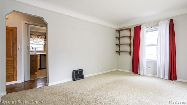 3446 17th St, Wyandotte, MI 48192 - spare room featuring carpet floors, arched walkways, and baseboards