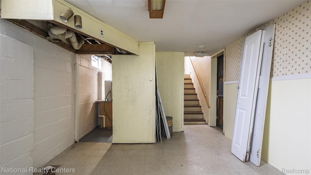 3446 17th St, Wyandotte, MI 48192 - finished basement with stairway, light floors, wallpapered walls, and concrete block wall