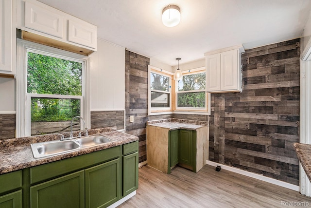 15500 Strathmoor St, Detroit, MI 48227 - kitchen with green cabinets, a sink, wood walls, light wood-style flooring, and white cabinets