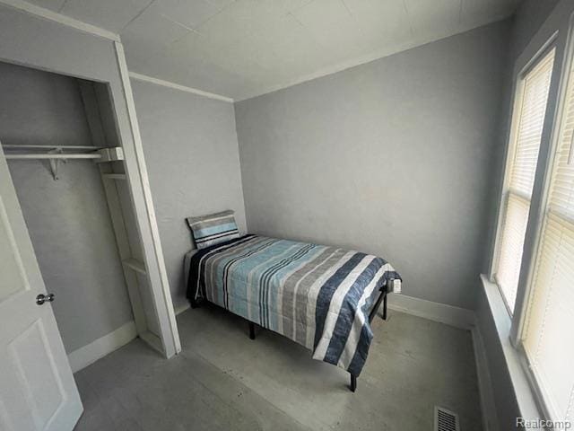 1010 S Garden St, Flint, MI 48503 - bedroom featuring concrete flooring, baseboards, and a closet