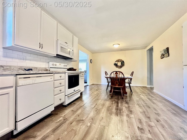 1865 Range Rd, Kimball, MI 48074 - kitchen with white appliances, light wood finished floors, white cabinetry, decorative backsplash, and baseboards