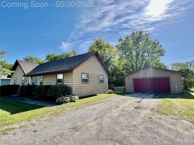 1865 Range Rd, Kimball, MI 48074 - view of side of property featuring a garage, an outbuilding, roof with shingles, and a yard