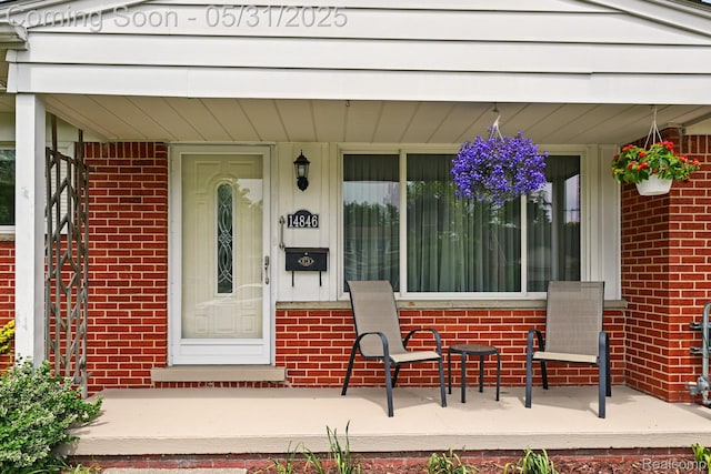 14846 Lakewood Dr, Plymouth, MI 48170 - doorway to property featuring covered porch and brick siding