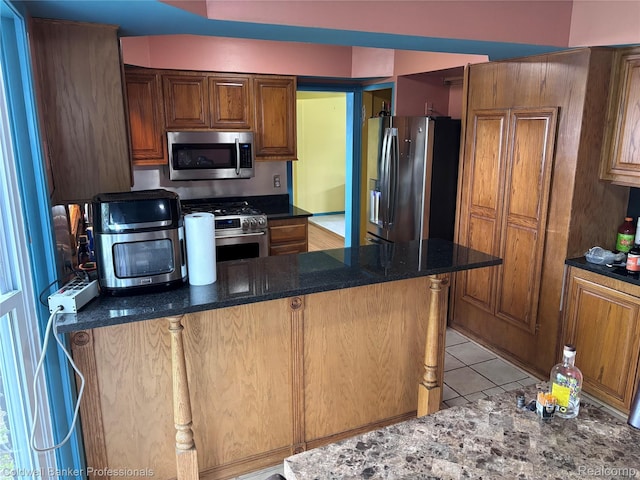 5550 25 Mile Rd, Shelby Twp, MI 48316 - kitchen featuring stainless steel appliances, light tile patterned floors, brown cabinetry, and dark stone counters