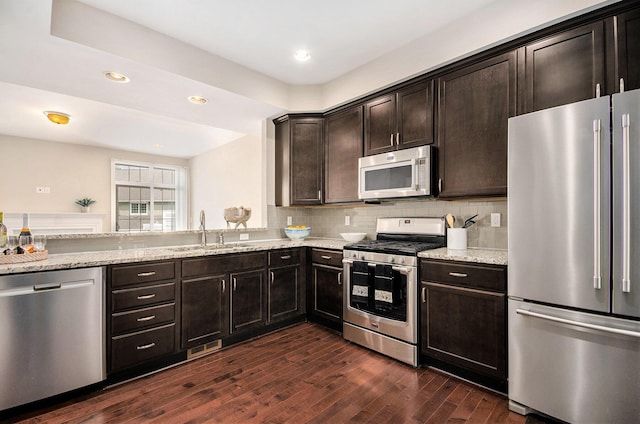 2512 W Liberty St, Ann Arbor, MI 48103 - kitchen featuring stainless steel appliances, a sink, light stone countertops, dark wood-style flooring, and dark brown cabinetry