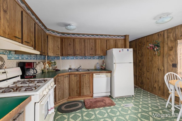 3570 109th Ave, Allegan, MI 49010 - kitchen featuring white appliances, a sink, light flooring, brown cabinets, and wooden walls
