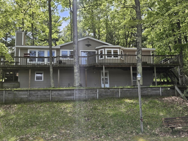 8862 W Rainbow Lake Dr, Baldwin, MI 49304 - rear view of house with a wooden deck, stairway, and a chimney
