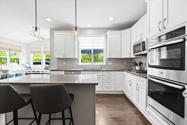 310 Fletcher St, Wixom, MI 48393 - kitchen featuring stainless steel appliances, a sink, plenty of natural light, a breakfast bar, and recessed lighting
