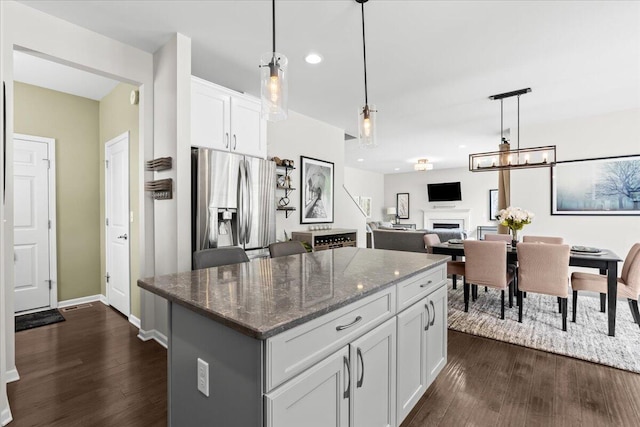 310 Fletcher St, Wixom, MI 48393 - kitchen with stainless steel refrigerator with ice dispenser, dark wood finished floors, dark stone counters, white cabinets, and recessed lighting