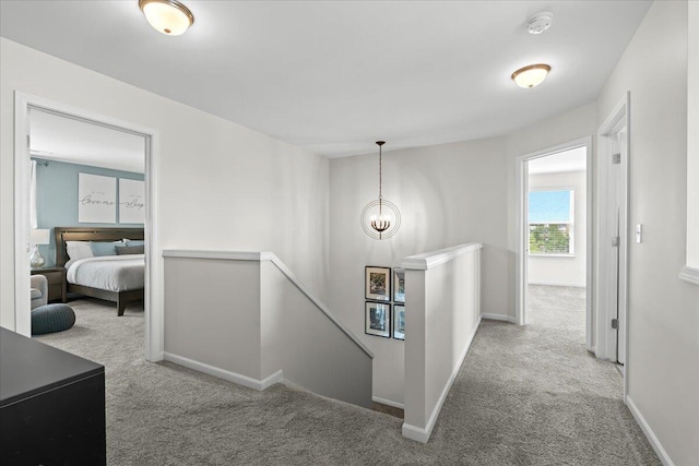 310 Fletcher St, Wixom, MI 48393 - hall with an upstairs landing, carpet floors, baseboards, and a chandelier