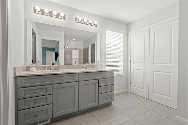 310 Fletcher St, Wixom, MI 48393 - bathroom with double vanity, a shower stall, baseboards, and tile patterned flooring